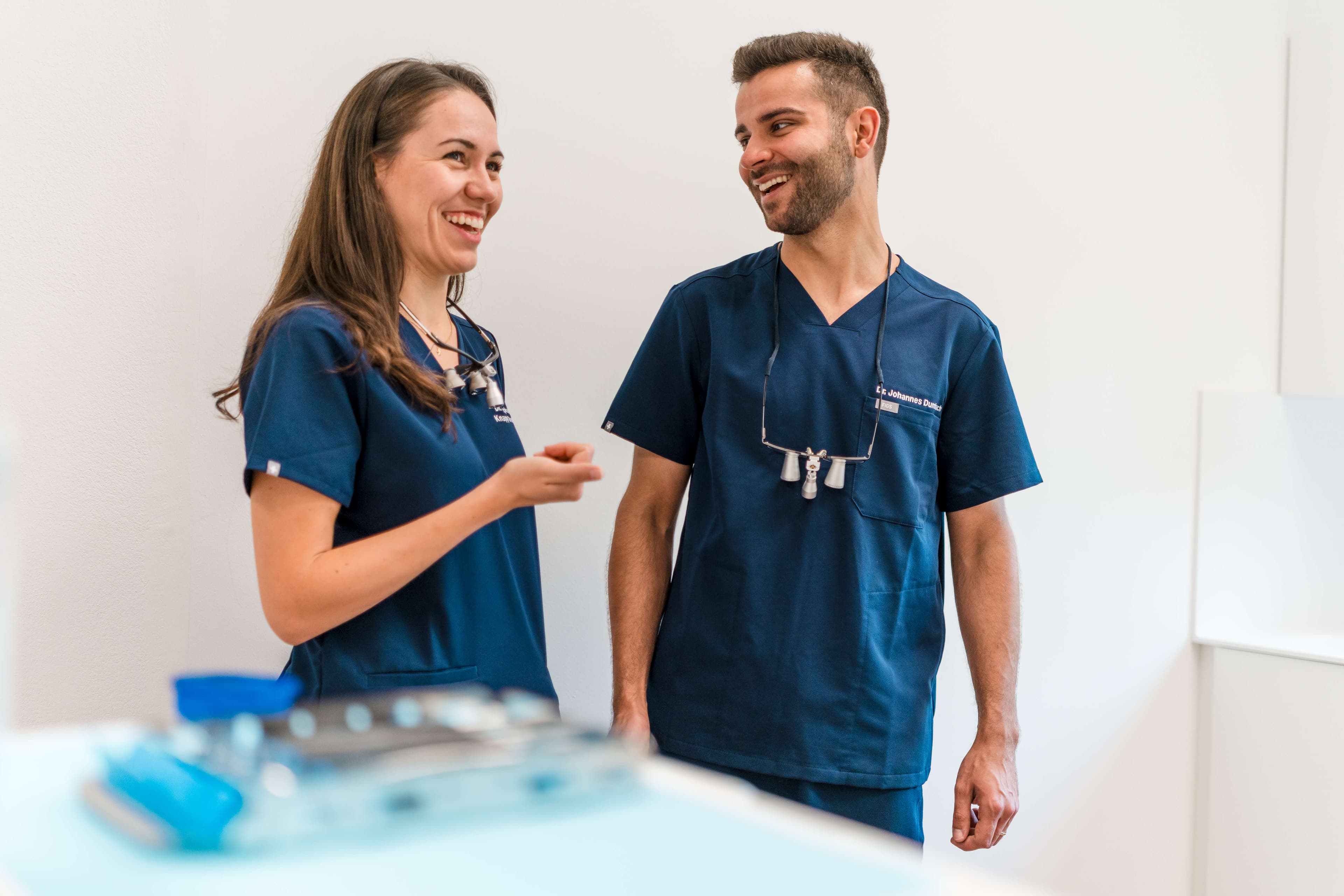 Dr. Stephanie Knapp Dumbach und Dr. Johannes Dumbach lachen gemeinsam im Behandlungszimmer